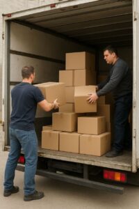 دو کارگر باربری در حال چیدمان کارتنها داخل کامیون. جعبههای سنگین در کف و جعبههای سبکتر در بالا قرار داده میشوند تا تعادل بار حفظ شود و هنگام حملونقل آسیبی وارد نشود.